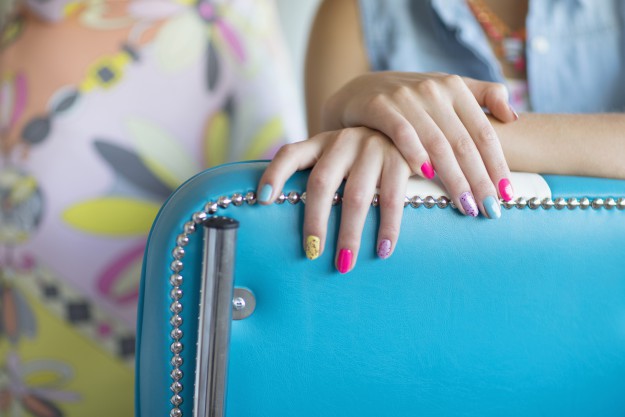 Close up of multicolor fingernail polish on woman's hands