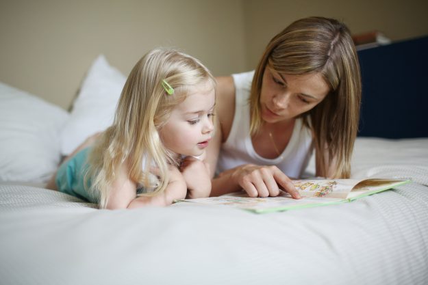 A mom and her daughter reading a book