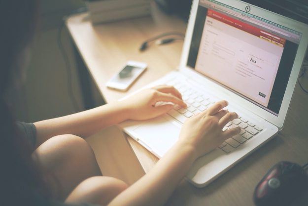 Cropped Image Of Woman Working On Laptop In Home